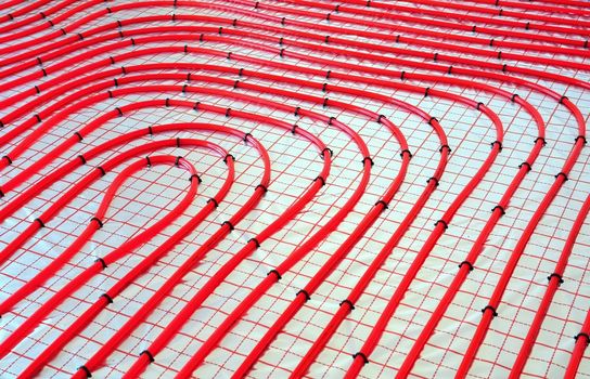 Water underfloor heating pipes on the silver reflective foil in house construction.