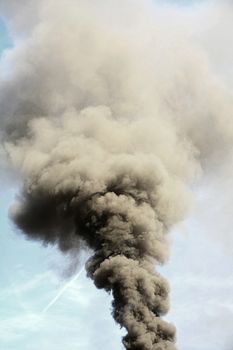 Environmental disaster and air pollution by big smoke column from chimney.