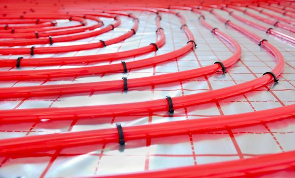 Close-up of water underfloor heating pipes on the silver reflective foil.