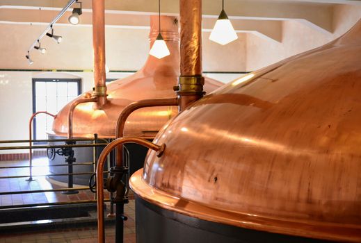 View of beer brewery interior with traditional fermenting copper vats.