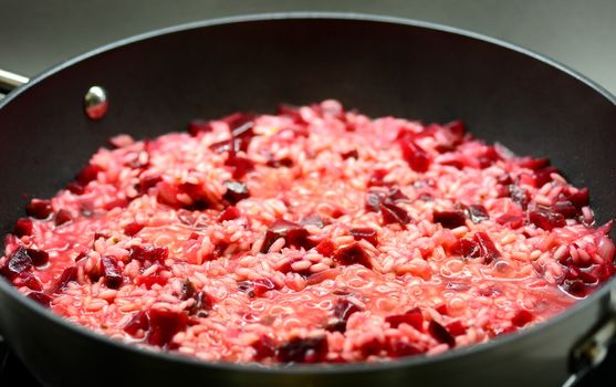 Close-up of a Italian Creamy Beetroot Risotto in the Black Pan.