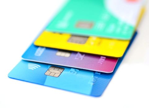 Stack of multicolored credit cards collection on white background.