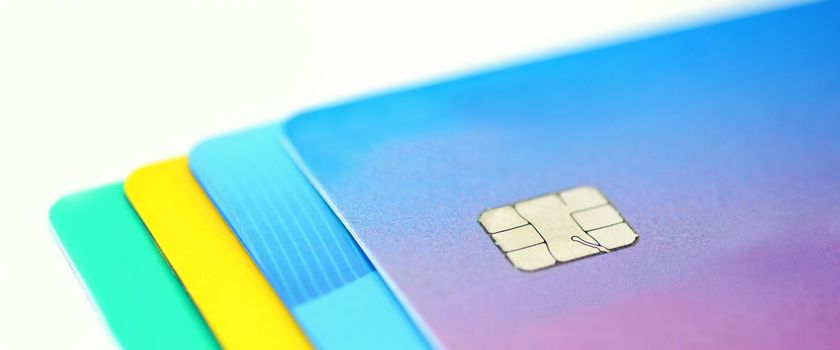 Stack of multicolored credit cards collection on white background.