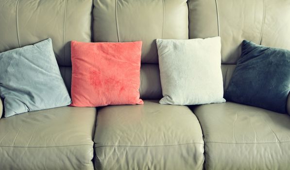 Full frame shot of light brown leather sofa with color suede pillows.