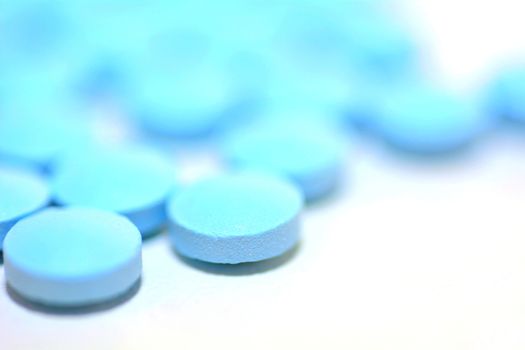 Macro of a Blue Pills on the White Background.