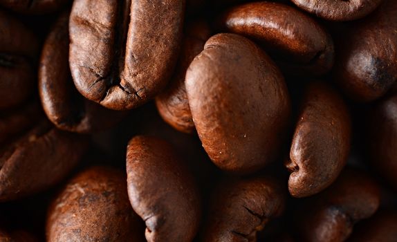 Roasted coffee beans full frame background. Macro shot of coffee beans with visible texture.