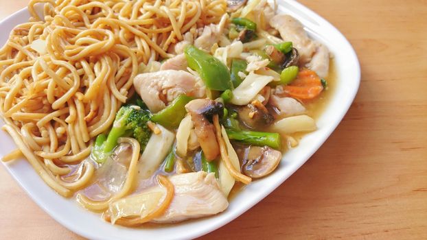 Chicken and Vegetable Stir Fry with Noodles on a White Plate.