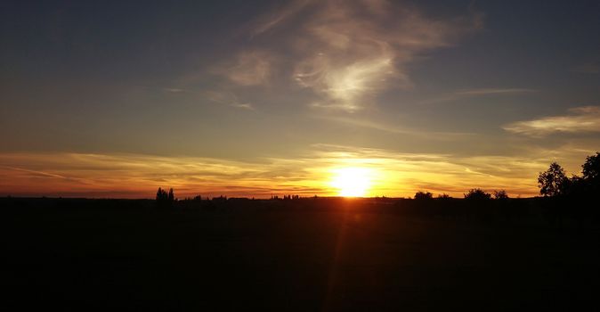 A beautiful colorful sunrise with yellow and orange sunlights over landscape.