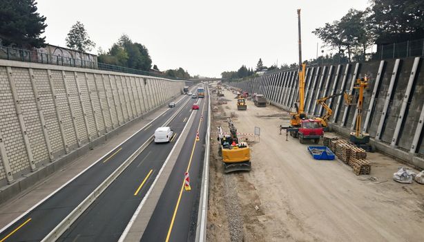 High angle view of highway reconstruction with workers and trucks.