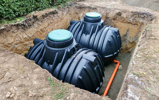 Two plastic underground storage tanks placed below ground for harvesting a rainwater.