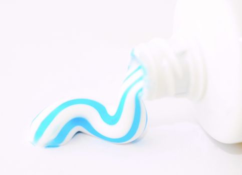 A toothpaste squeezed from a tube on white background.