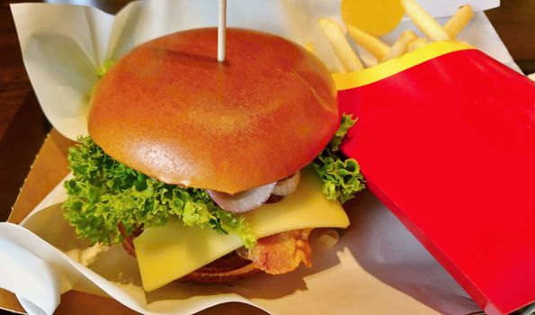 Closeup of hamburger with french fries on the tray in fast food restaurant.