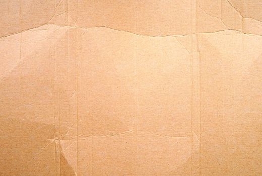 Full frame texture of blank crumpled and wrinkled brown cardboard background.