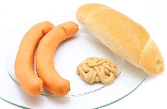 A plate of two frankfurter sausages with bread roll and mustard over white background. 