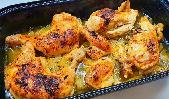 Top View of Pan Full of Oven-Baked Chicken Legs and Chicken Quarters