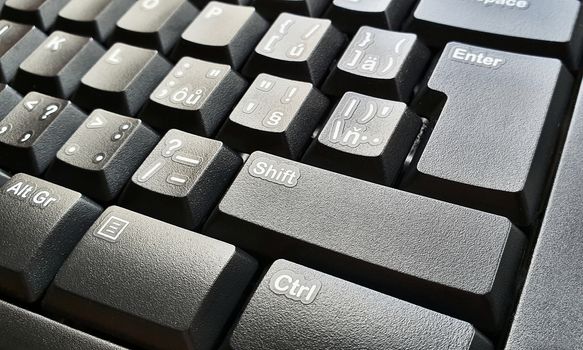 Closeup of black keyboard keys. Selective focused on foreground, shift key.