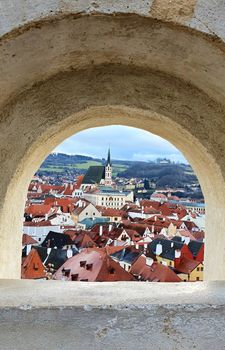 A view of beautiful town Cesky Krumlov through the castle wall window.