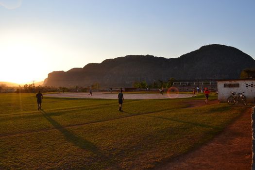 Vinales, Cuba, March 2020: people playing a ball game on a sports field in Cuba during sunset