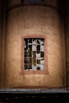 Damaged industrial window on factory wall closeup