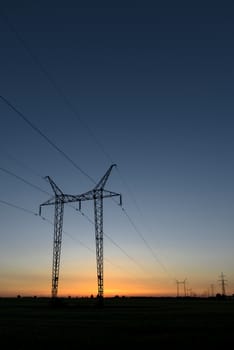 Large transmission towers at sunset with horizon