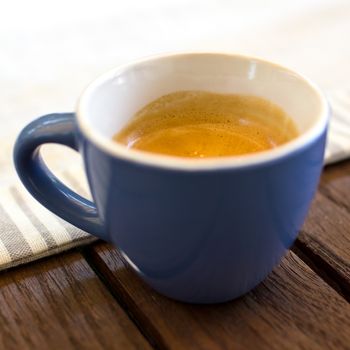 A cup of espresso, isolated on background out of focus.