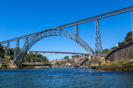 Maria Pia Bridge over the Douro river, Porto, Portugal. View from the water. Wrought iron railway bridge. One of the most popular touristic destinations.