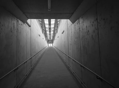 Empty concrete undergound passage platform subway on train station, balck and white, diminishing perspective.