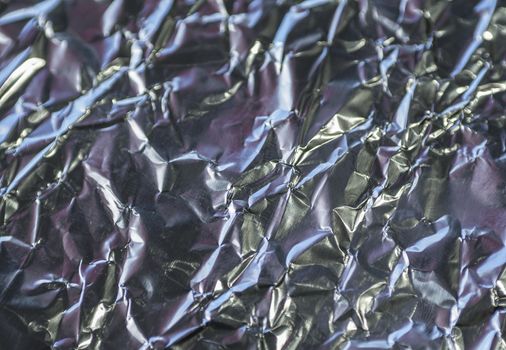 close up crumpled aluminium tinfoil silver pink background