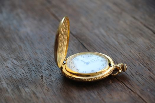 Golden pocketwatch classic design watch 10.10 hour put on wood table background