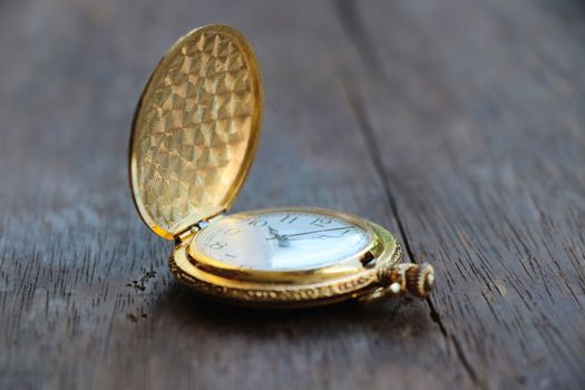 Golden  pocketwatch classic design watch 10.10 hour put on wood table background