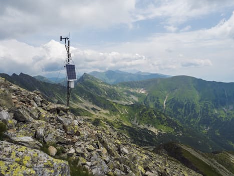 Top of the peak Banikov at Western Tatra mountains or Rohace. Sharp green mountains - ostry rohac, placlive and volovec with hiking trail on ridge. Summer blue sky white clouds