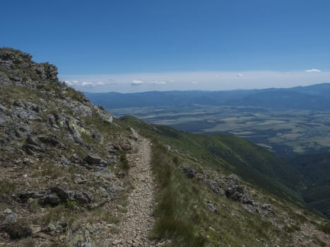 view on valley of Liptovsky Mikulas from hiking trail on Baranec peak at Western Tatra mountains or Rohace. Summer blue sky background.