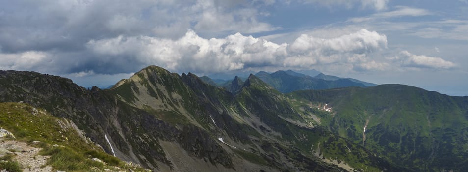 Panoramic view from Banikov peak on Western Tatra mountains or Rohace panorama. Sharp green mountains - ostry rohac, placlive and volovec with hiking trail on ridge. Slovakia. Summer blue sky white clouds.