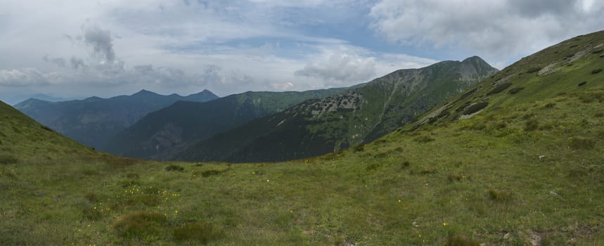 View from tatra mountain trail on Baranec to Western Tatra mountains or Rohace panorama. Grassy meadow hills, blue sky. Tatra mountain in summer, Slovakia