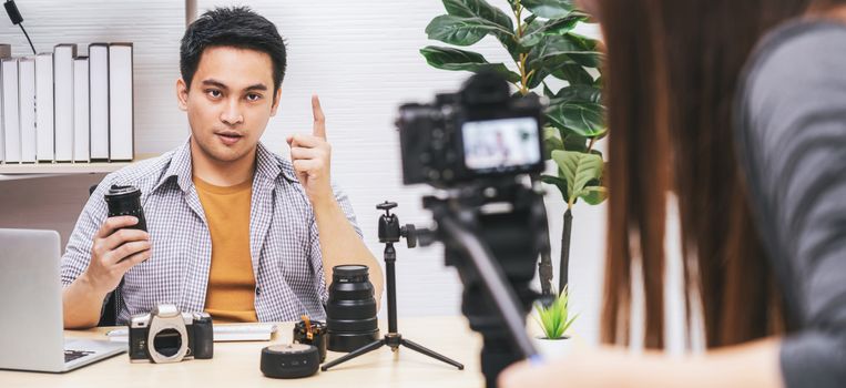 Banner Camera taking video and live with laptop of Asian Vlogger man satisfied the camera lens each media, sharing knowledge to audience via camera by social media channel,vlog and Influencer concept