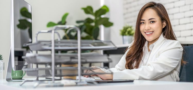 Banner of Asian business woman working and typing keyboard of technology computer in happy action at office desk, startup and entrepreneur, businessperson and small business concept