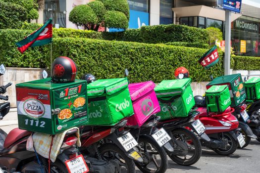 BANGKOK, THAILAND - APRIL 2020 : Various food delivery box on the motorcycles include Grab Food, Food Panda and Pizza at Food delivery service point on April 17, 2020, Bangkok,Thailand, Covid outbreak