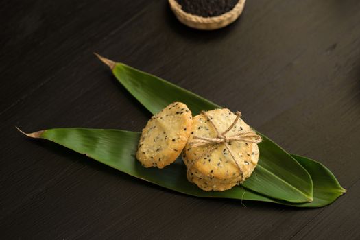 Sesame Cookies, sesame and milk on black wooden background.