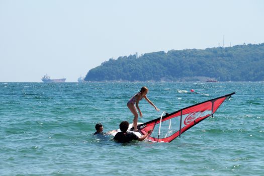 Varna, Bulgaria - July,31,2020: instructors teach the child to ride windsurfing