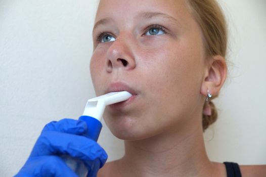 girl breathing through an inhaler, portrait close-up