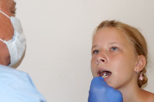 the doctor takes a test for coronavirus from the girl's mouth.