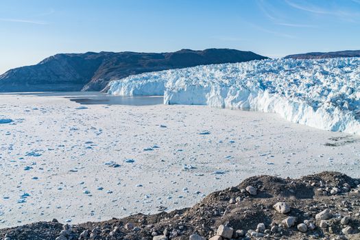 Climate Change Concept. Greenland Glacier heavily affected by Global Warming. Glacier front of Eqi glacier in West Greenland AKA Ilulissat and Jakobshavn Glacier. Produces many of Greenlands icebergs.
