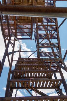 old rusty metal ladder in a blue sky with clouds