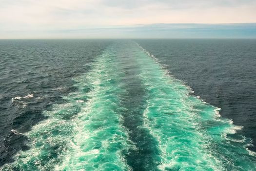 A trail on the water from the ship. The propellers of the ship smeared the water.