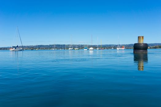 Boats moored in bay at Omokoroa Tauranga New Zealand from water level perspective.