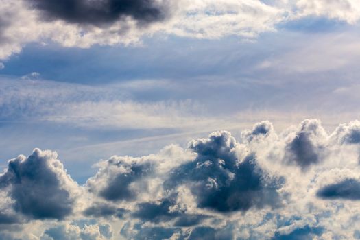 distant misty backlit cumulus and feather clouds near horizon closeup telephoto shot with polarizing effect