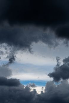 Incoming storm close-up cloudscape at march daylight in continental europe. Horse like form gap in dence cloud, captured with telephoto lens.