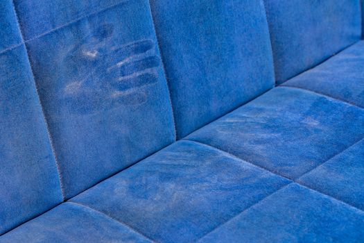 dusty blue sofa surface with palm prints closeup with selective focus.