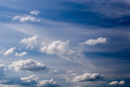 Regular spring clouds on blue sky at daylight in continental europe. Shot wit telephoto lens and circular polarizing filter.