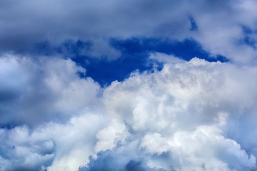 Regular spring clouds on blue sky at daylight in continental europe. Close shot wit telephoto lens and circular polarizing filter.